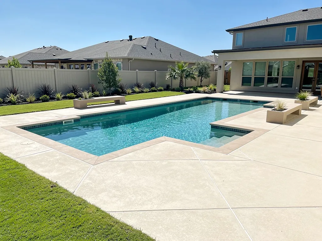 Concrete pool deck at a Hills Texas home with stamped border and broom finish